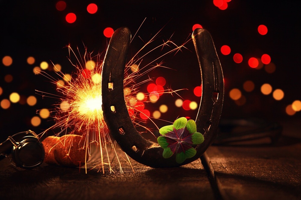 Hufeisen mit Wunderkerze und Glücksklee – Symbolbild zum Thema Silvester mit Pferd